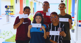 jovens exibindo o título que tiraram na escola durante lançamento do projeto voto jovem