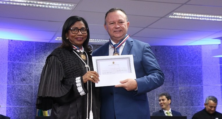 Presidente Angela Salazar entregando a Medalha do Mérito Eleitoral ao governador Carlos Brandão